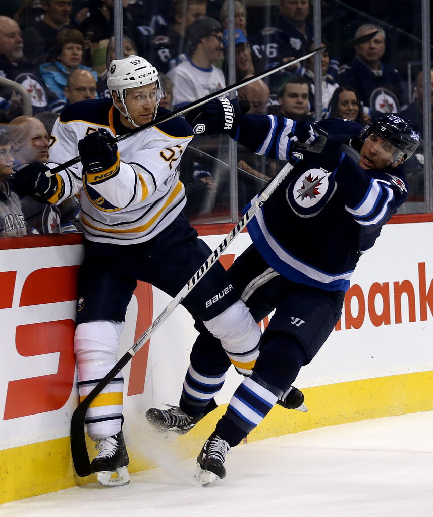 Trevor Hagan / The Canadian Press
Winnipeg Jets' Blake Wheeler, right, hits Buffalo Sabres' Alexander Sulzer (#52) into the boards behind the Buffalo goal in the second period.