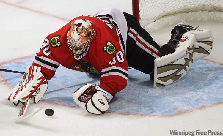 Chicago Blackhawks goaltender Ray Emery dives for the puck after a shot by the Winnipeg Jets with 2 seconds left in the third period. (Joe Bryksa / Winnipeg Free Press)