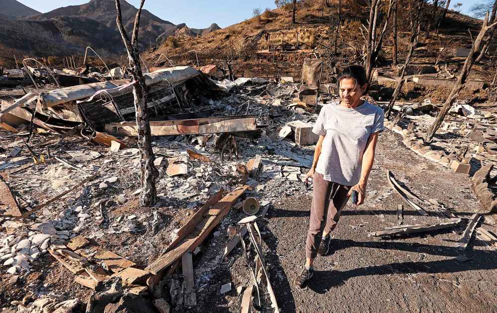 Seminole Springs Mobile Home Park resident Barbara Sottile walks past homes of friends destroyed by the Woolsey Fire on Mulholland Drive in Agoura Hills, Calif. Nearly 200 of the 270 homes in Seminole Springs were destroyed. (Al Seib / Los Angeles Times)