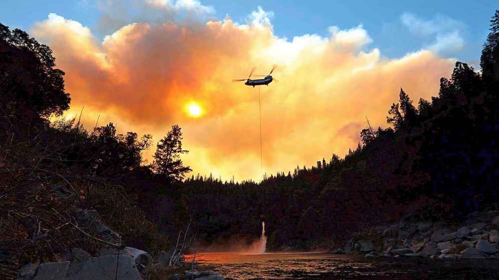 Outside of Pulga, Calif. on the North Fork of the Feather River, helicopters do airdrops while ground crews try to keep the fire from spreading on Sunday. (Carolyn Cole / Los Angeles Times)