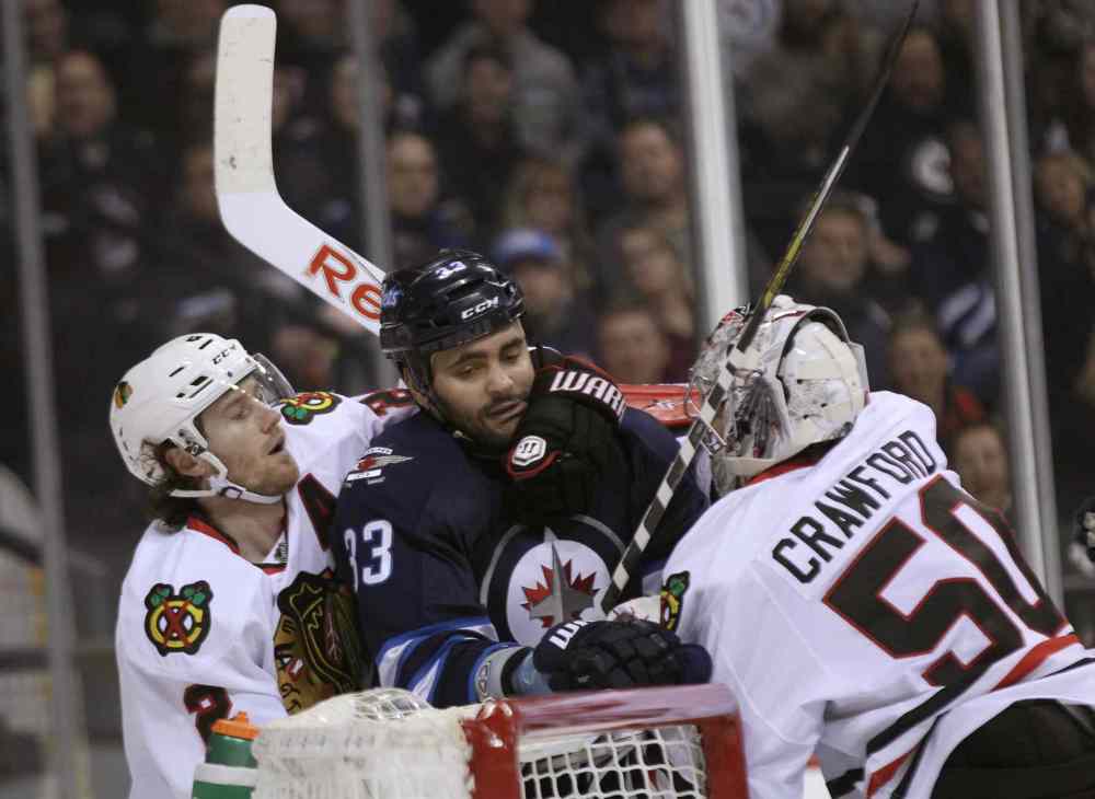 JOE BRYKSA / WINNIPEG FREE PRESS
Winnipeg Jets' Dustin Byfuglien is manhandled by Chicago Blackhawks' Duncan Keith and goaltender Corey Crawford during second period NHL hockey at the MTS Centre in Winnipeg Friday night.