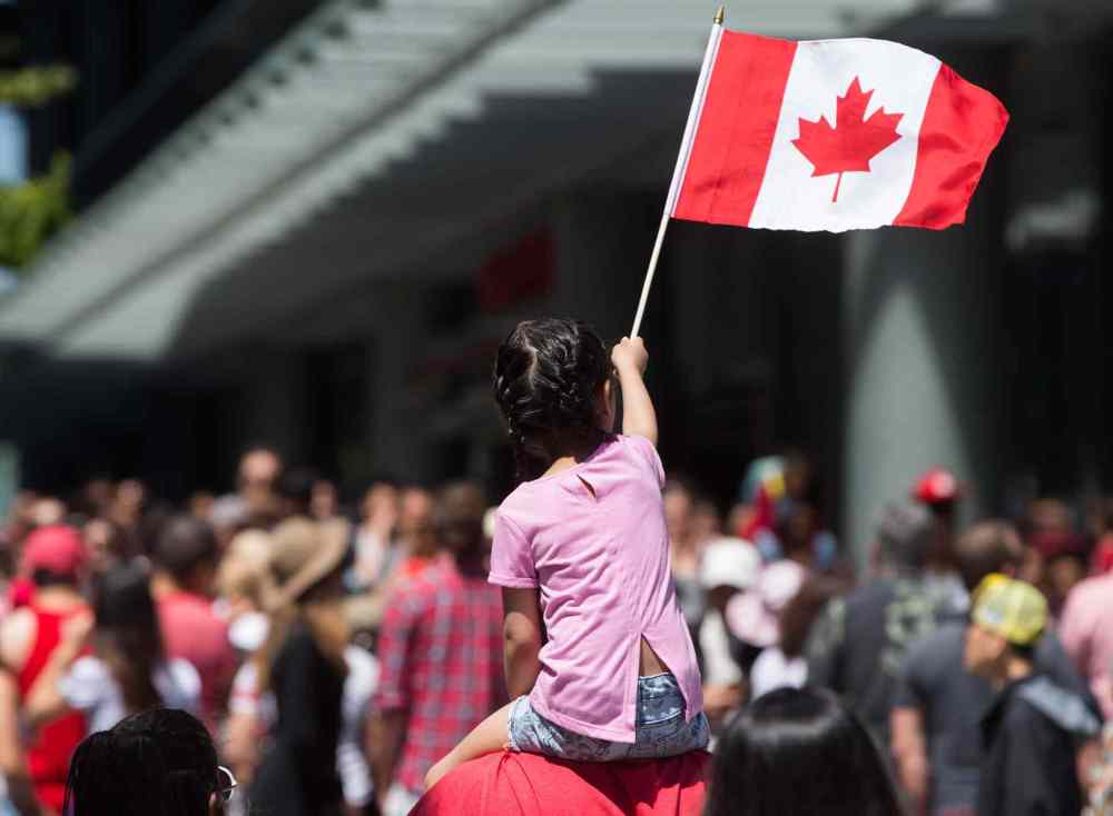 DARRYL DYCK / THE CANADIAN PRESS
A young girl waves a Canadian flag while being carried through the crowd during Canada Day celebrations in Vancouver, B.C.