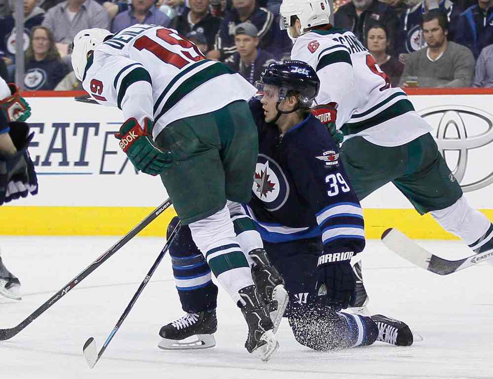 JOHN WOODS / WINNIPEG FREE PRESS
Minnesota's Stephane Veilleux gets checked by Jets defenceman Tobias Enstrom during second-period play.