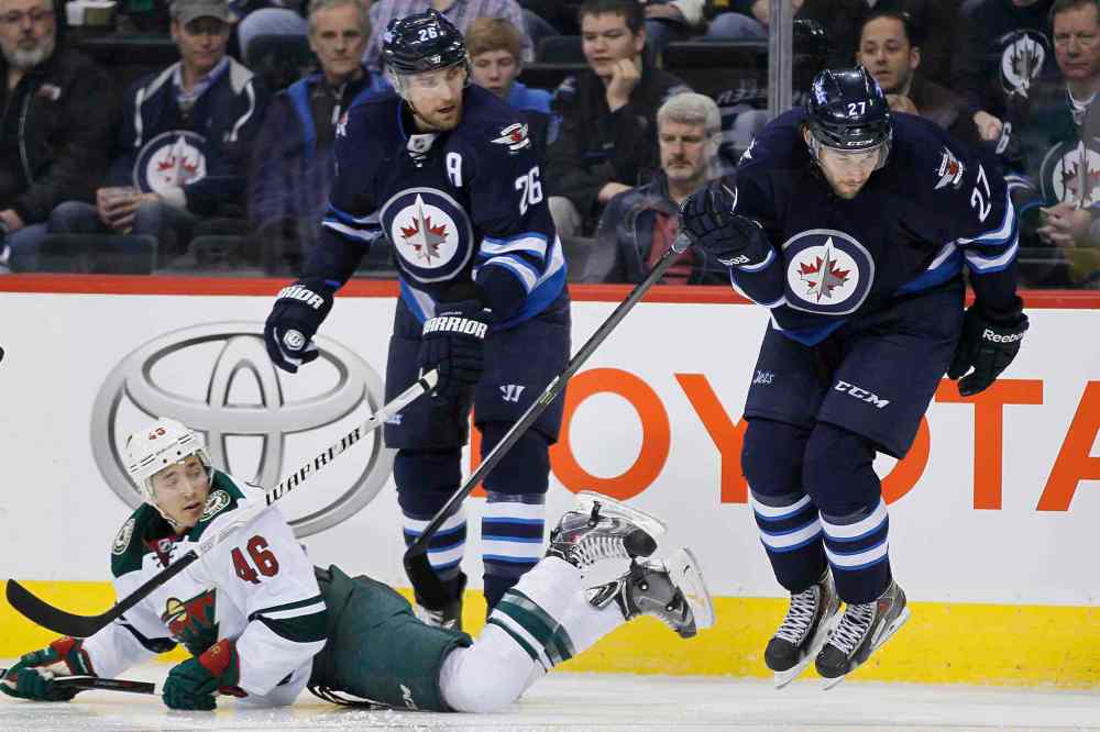 JOHN WOODS / WINNIPEG FREE PRESS
Jets forwards Blake Wheeler, left, and Eric Tangradi check Minnesota's Jared Spurgeon in the second period.