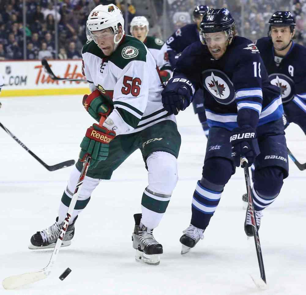 CRYSTAL SCHICK / WINNIPEG FREE PRESS
Winnipeg forward Bryan Little and Minnesota's Erik Haula battle for the puck during first-period action.