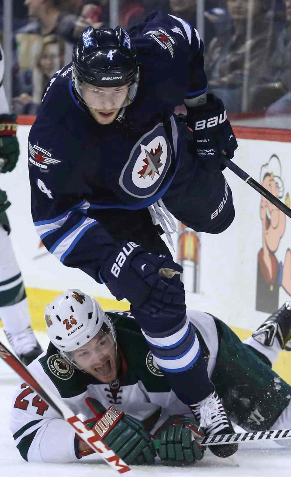 CRYSTAL SCHICK / WINNIPEG FREE PRESS
Jets defenceman Paul Postma gets tripped up by Wild forward Matt Cooke in the first period.