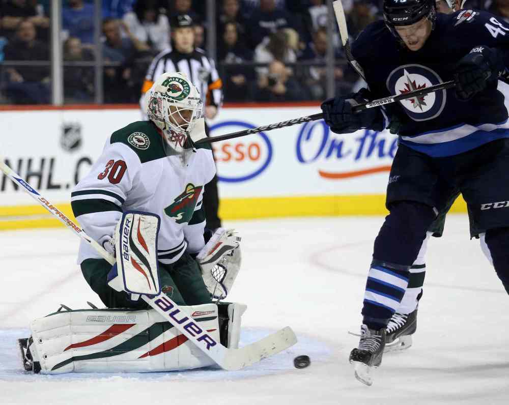 TREVOR HAGAN / THE CANADIAN PRESS
The Wild's Ilya Bryzgalov takes a stick to the mask from the Jets' Carl Klingberg during the second period.