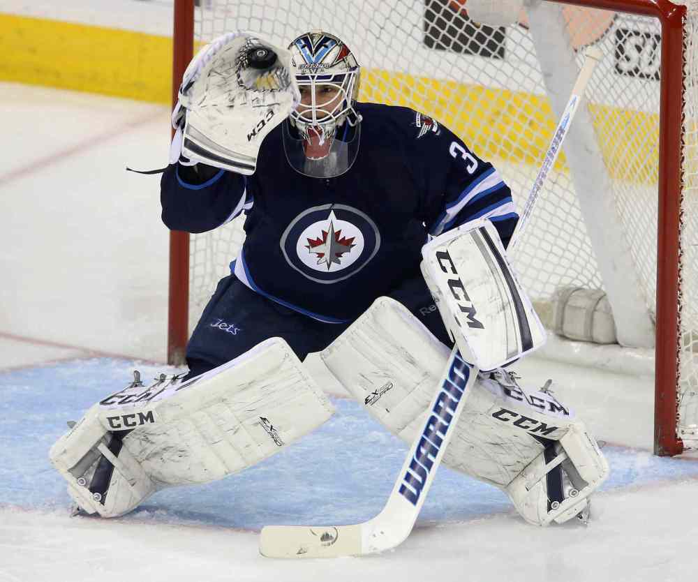 TREVOR HAGAN / THE CANADIAN PRESS
In his first NHL start, Jets goaltender Michael Hutchinson makes a glove save against the Minnesota Wild during the first period.