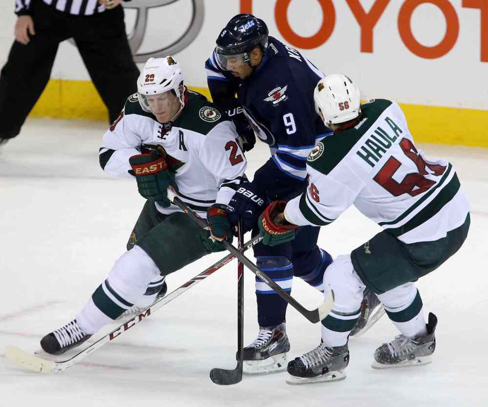 TREVOR HAGAN / THE CANADIAN PRESS
The Minnesota Wild's Ryan Suter (20) and Erik Haula sandwich Jets forward Evander Kane during third-period play.