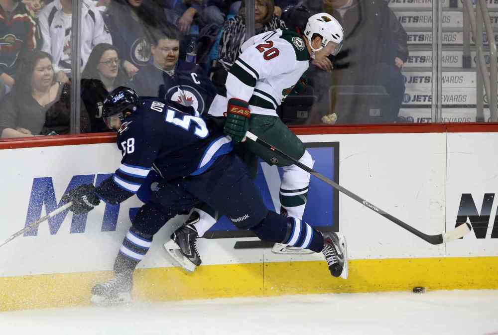 TREVOR HAGAN / THE CANADIAN PRESS
The Jets' Eric O'Dell collides with the Wild's Ryan Suter in the third period.