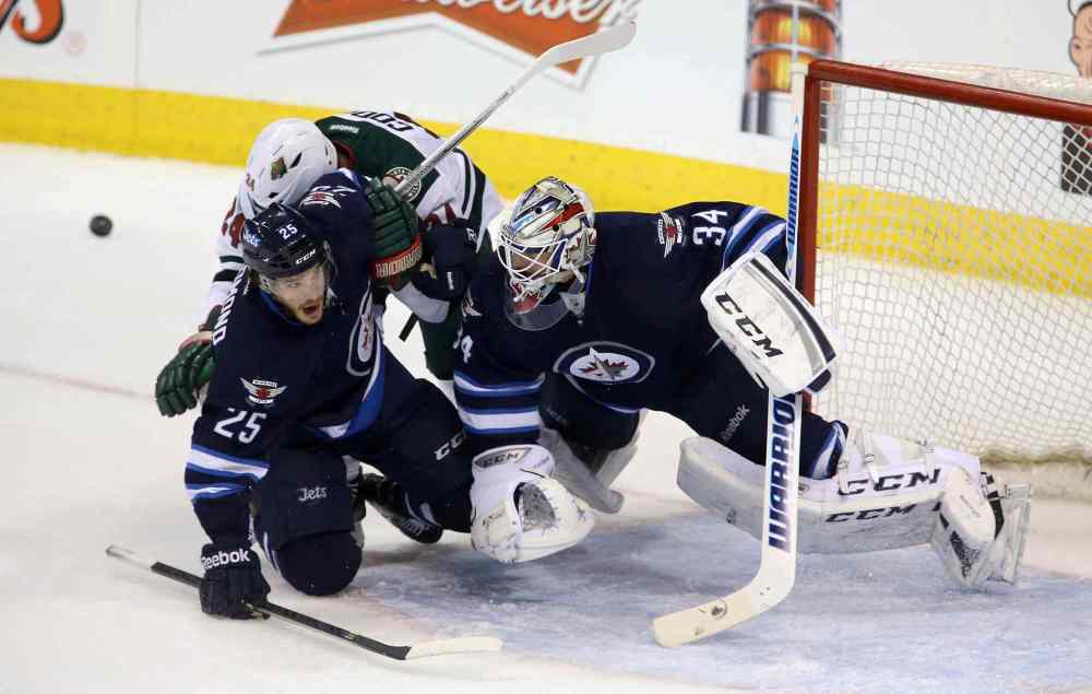 TREVOR HAGAN / THE CANADIAN PRESS
The Wild's Matt Cooke collides with Jets defenceman Zach Redmond and goaltender Michael Hutchinson in the first period.