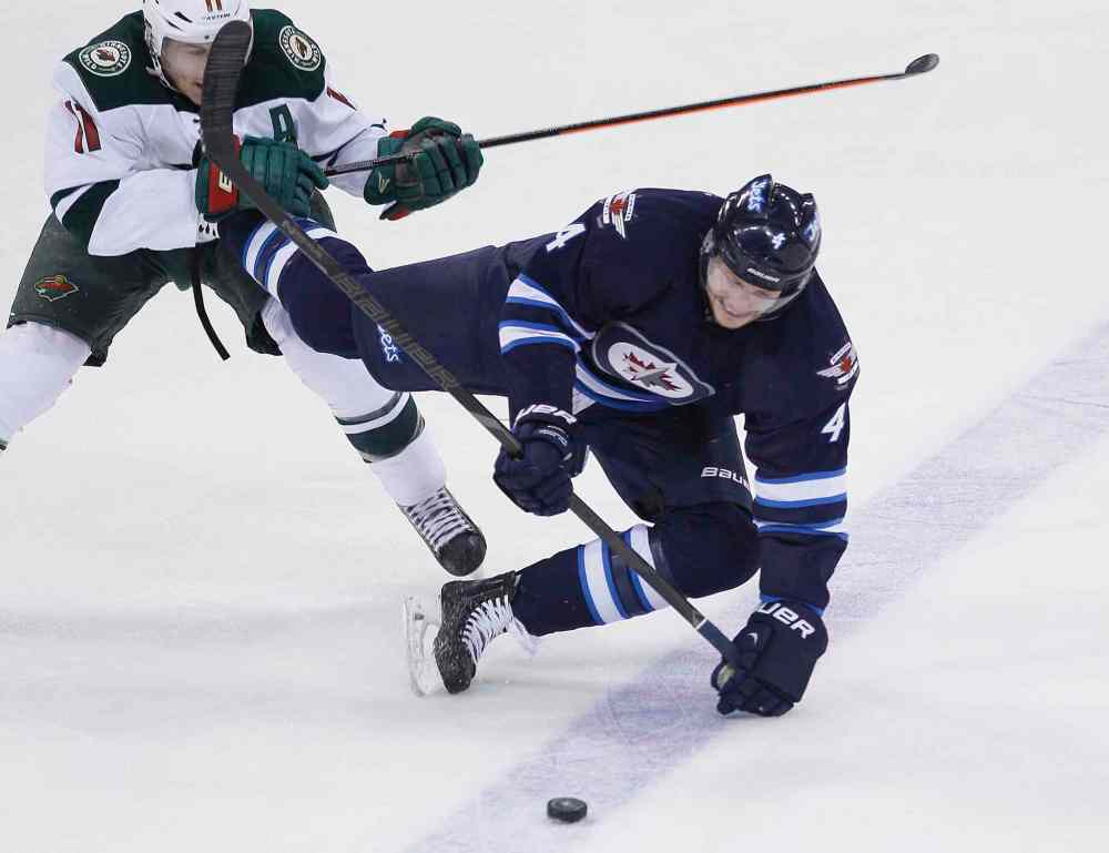 JOHN WOODS / WINNIPEG FREE PRESS
Wild forward Zach Parise trips Jets defenceman Paul Postma during the first period.