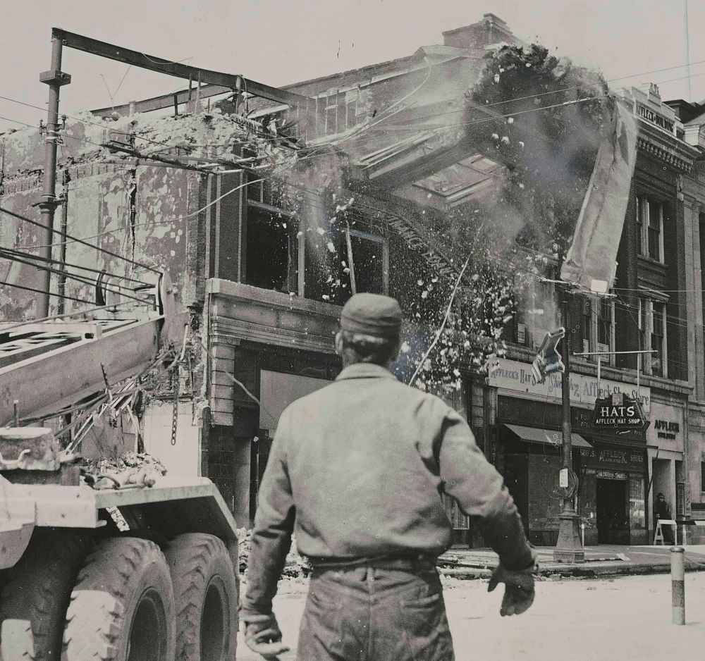 WINNIPEG FREE PRESS FILES
The front wall of the Edwards Block is sent crashing to the ground as three crane trucks with steel cables tug at its girders. As the building fell, the road shuddered under the impact.