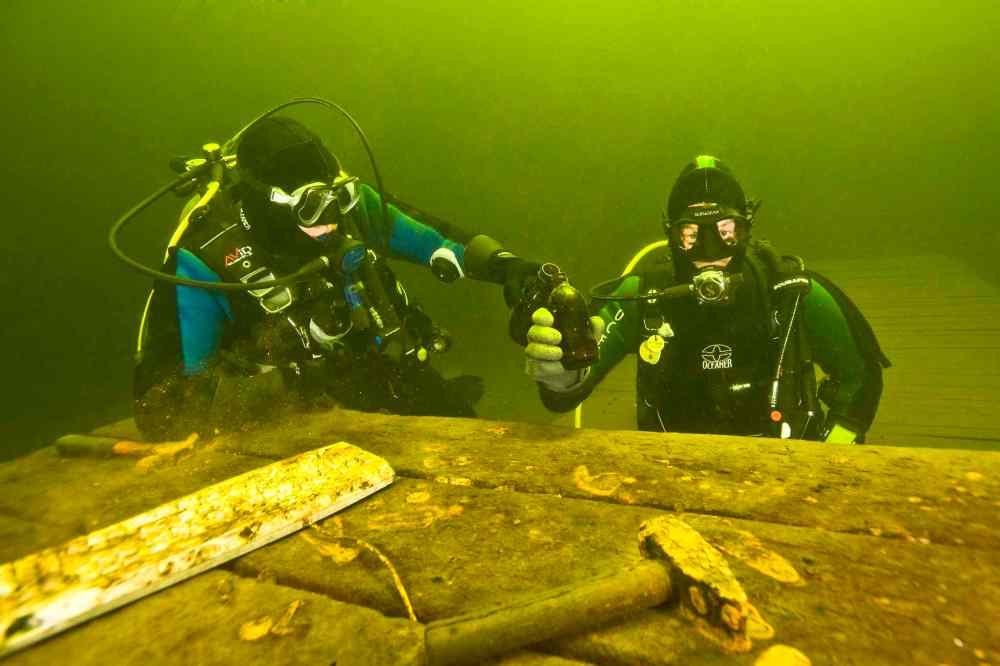 Two divers toast at a tool table found 40 feet (12 metres) below the lake's surface.