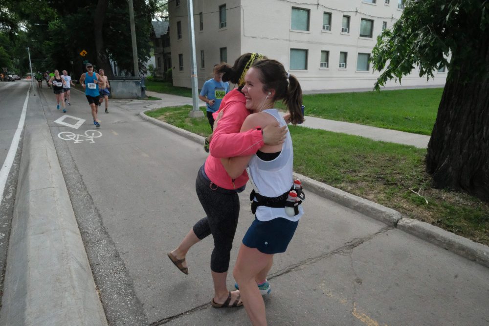 DANIEL CRUMP / WINNIPEG FREE PRESS
Marathon supporter Janet Young (pink jacket) hugs a runner at the 40th Manitoba Marathon, Sunday, June 17, 2018.
