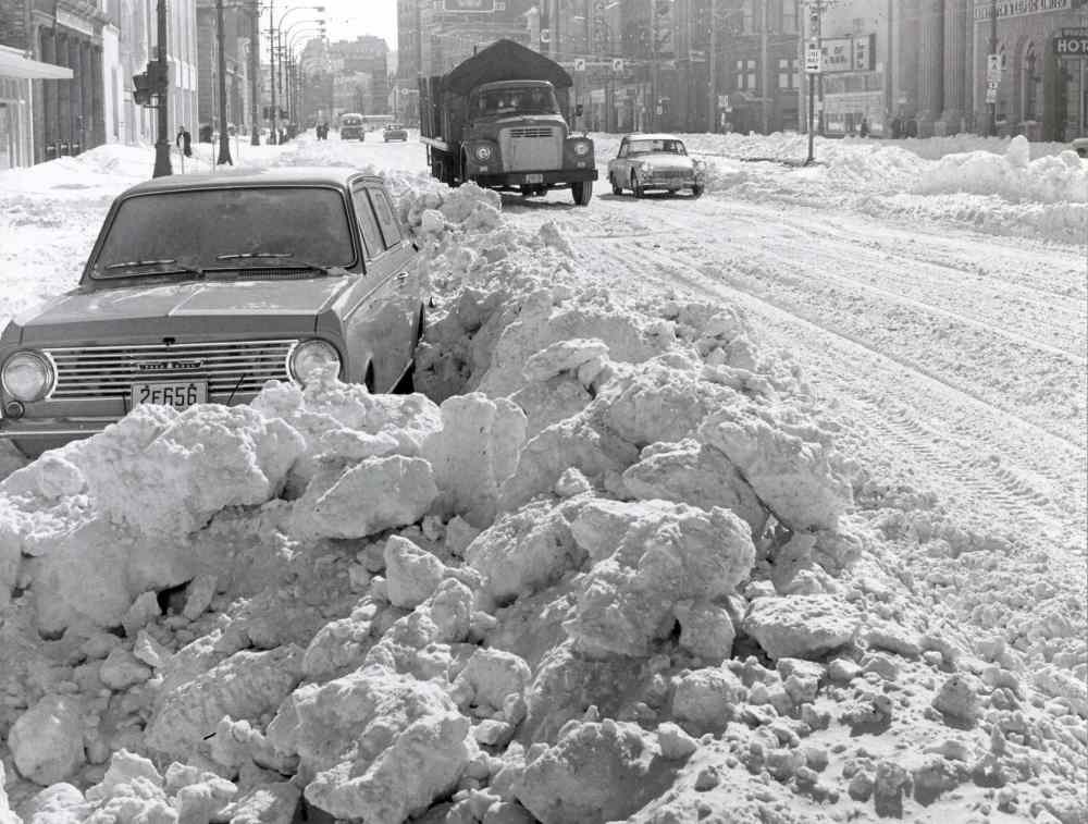 Cars abandoned, then stuck in plowed snow, along Main Street (Gerry Cairns / Winnipeg Free Press Archives)