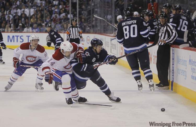 Alexander Burmistrov battles for the puck with Canadien Tim Stapleton during the second-period. (Trevor Hagan / Winnipeg Free Press)
