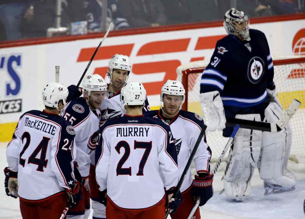 Trevor Hagan / Winnipeg Free Press
Columbus Blue Jackets' Derek MacKenzie (24), Mark Letestu (55), RJ Umberger (18), Ryan Murray (27) and James Wisniewski (21) celebrate after Letestu scored on Winnipeg Jets' goaltender Ondrej Pavelec (31) during the third period Saturday.