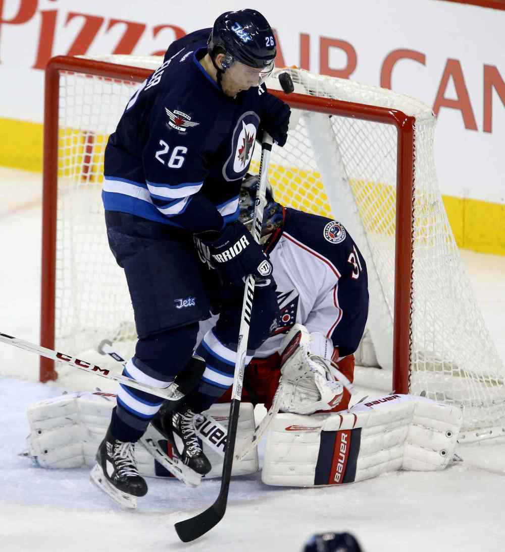 Trevor Hagan / Winnipeg Free Press
Winnipeg Jets' Blake Wheeler (26) nearly gets a puck in the face in front of Columbus Blue Jackets' goaltender Curtis McElhinney (31) during the third period Saturday.