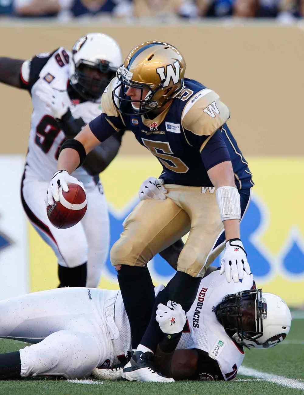 John Woods / The Canadian Press
Winnipeg Blue Bombers' quarterback Drew Willy (5) gets sacked by Ottawa Redblacks' Jonathan Williams (75) during the first half Thursday's game.