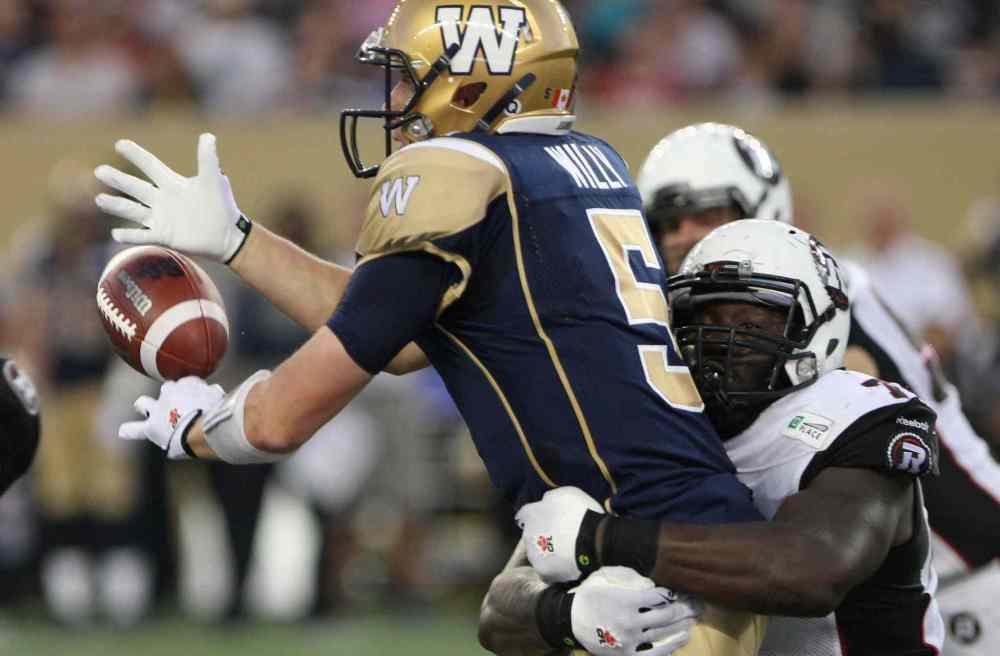 JOE BRYKSA / WINNIPEG FREE PRESS
Winnipeg Blue Bombers' quarterback Drew Willy takes a big hit from Ottawa Redblacks' Jonathan Williams during the second half of Thursday's game.