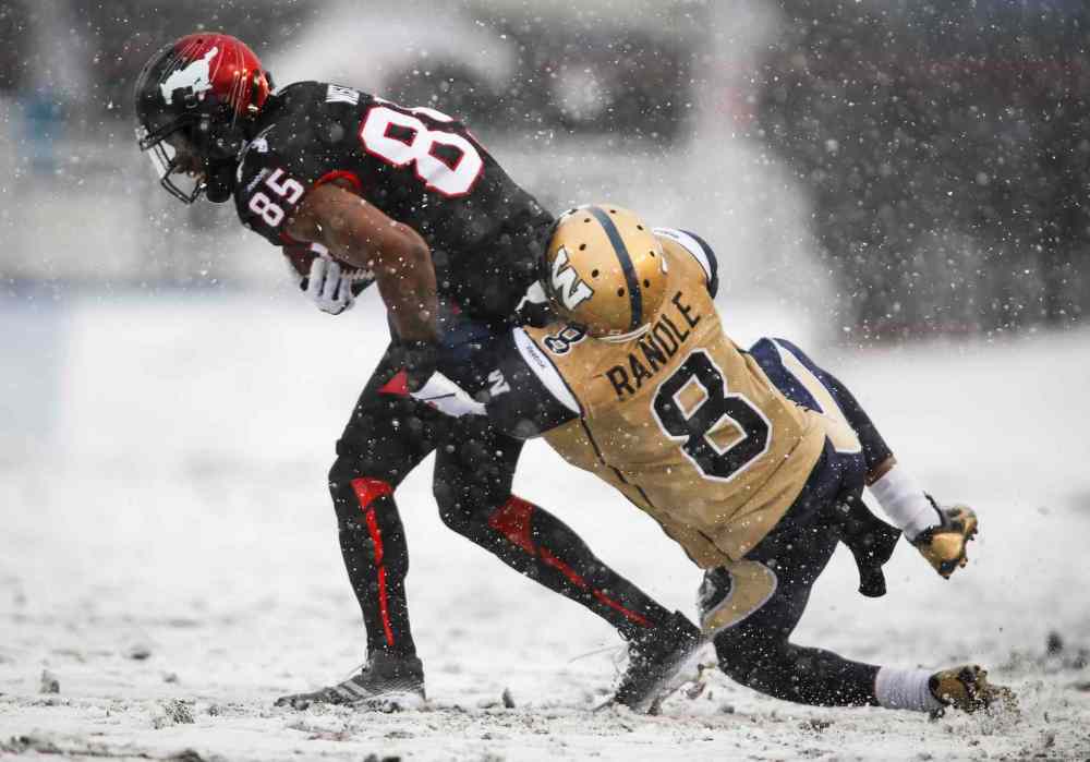 Jeff McIntosh / The Canadian Press
Winnipeg Blue Bombers' Chris Randle, right, tries to bring down Calgary Stampeders' Joe West during the second half in snowy Calgary Saturday.