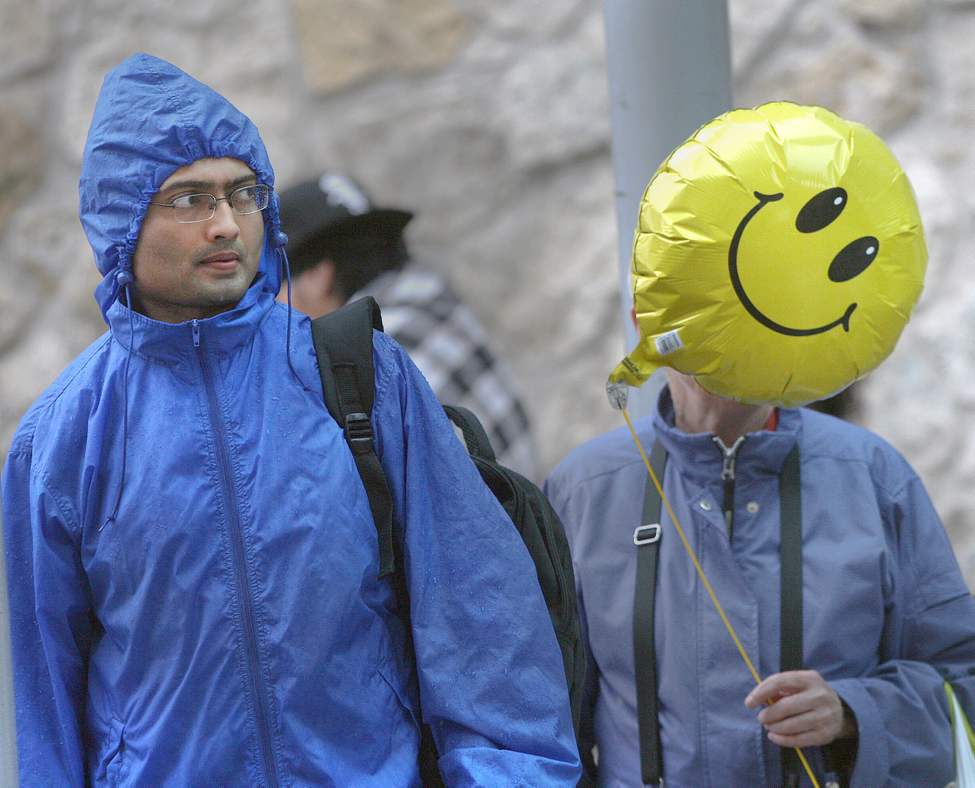 Keep Smiling Winnipeg- Two people wait for a bus in the rain in downtown Winnipeg. May 30, 2013 (JOE BRYKSA / WINNIPEG FREE PRESS)