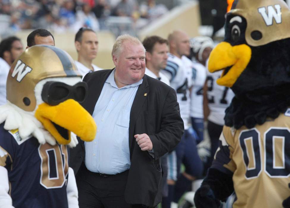 Toronto Mayor Rob Ford was in attendance watching the Toronto Argonauts play the Winnipeg Blue Bombers during Friday night CFL action in Winnipeg at Investors Group Field �Buzz, left, and Boomer mascots of the Bombers have some fun. July 19, 2013 (JOE BRYKSA/WINNIPEG FREE PRESS)