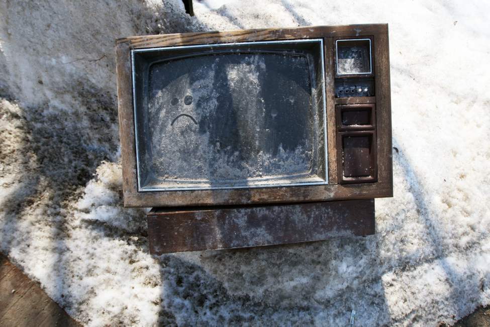 Turned off- An expired television sits in a snow bank in the back alley of Mountain Avenue. April 19, 2013 (JOE BRYKSA / WINNIPEG FREE PRESS)