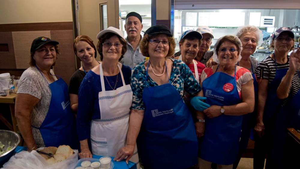 Danielle Da Silva - Sou'wester
The kitchen volunteers of the Greek pavilion take a break after a busy dinner service to pause for a photo and enjoy the Zorbas dance.