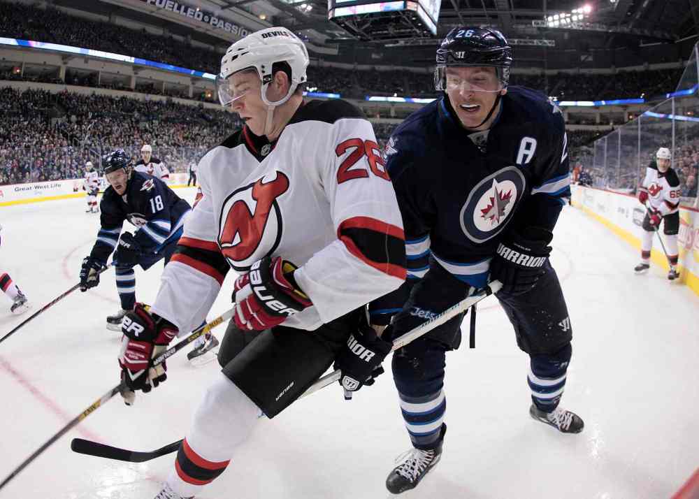 John Woods / The Canadian Press
New Jersey Devils' Damon Severson (28) and Winnipeg Jets' Blake Wheeler (26) work the puck in the corner during the second period of Tuesday's game.