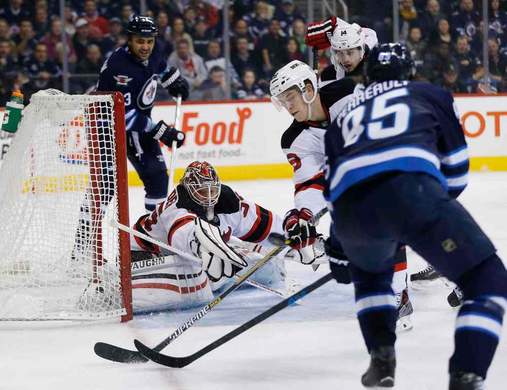 John Woods / The Canadian Press
New Jersey Devils' goaltender Cory Schneider (35) knocks the puck away as Winnipeg Jets' Mark Scheifele (55) looks for the rebound and Devils' Damon Severson (28) defends during the second period of Tuesday's game.