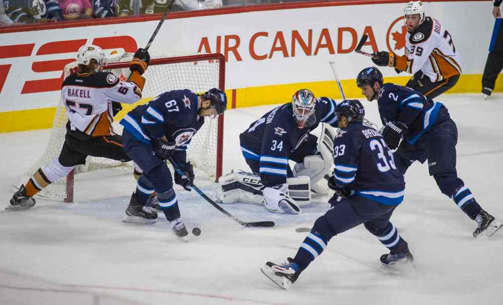 DAVID LIPNOWSKI / WINNIPEG FREE PRESS
The Winnipeg Jets try to get rid of the puck while playing against the Anaheim Ducks in the first period of Saturday's game.