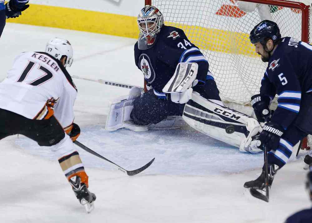 John Woods / The Canadian Press
Winnipeg Jets goaltender Michael Hutchinson (34) gets a leg on the shot from Anaheim Ducks Ryan Kesler (17) as Jets' Mark Stuart (5) defends during first-period NHL action.