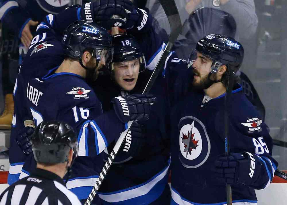 John Woods / The Canadian Press
Winnipeg Jets' Andrew Ladd (16), Bryan Little (18) and Matthieu Perreault (85) celebrate Little's first-period goal against the Anaheim Ducks.