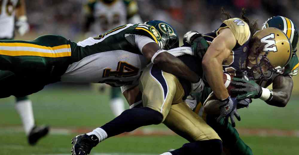 Phil Hossack / Winnipeg Free Press
Winnipeg Blue Bombers' Julian Feoli-Gudino clings to the ball as he goes down on a flying tackle from Edmonton Eskimos' #40 Deon Lacey in the third quarter Thursday.