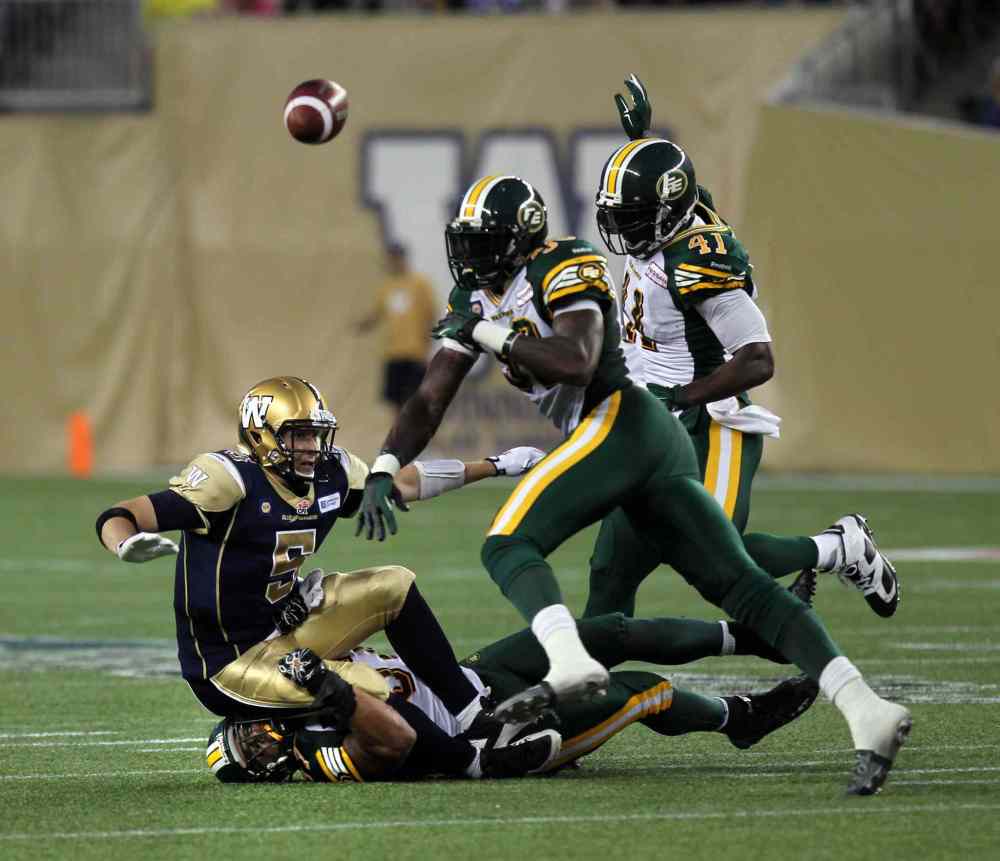 Phil Hossack / Winnipeg Free Press
Winnipeg Blue Bombers' quarterback Drew Willy goes down hard on top of Edmonton Eskimos' Eddie Steele while defenders #39 Corbin Sharun and #41 Odell Willis complete the third-quarter play.