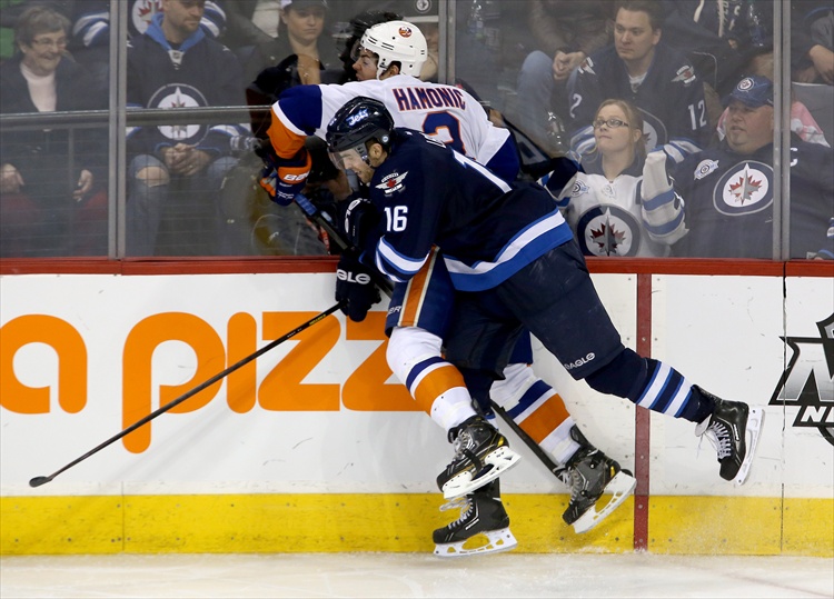Trevor Hagan / Winnipeg Free Press
Travis Hamonic is hit hard into the boards by Andrew Ladd during the third period.