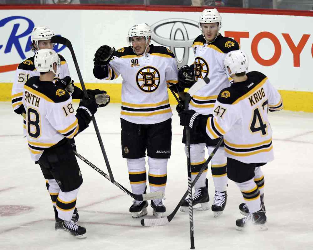 Phil Hossack / Winnipeg Free Press
Boston Bruin linemates congratulate #63 Brad Marchand (centre) for scoring the Bruins' opener in the first period of Thursday's game.