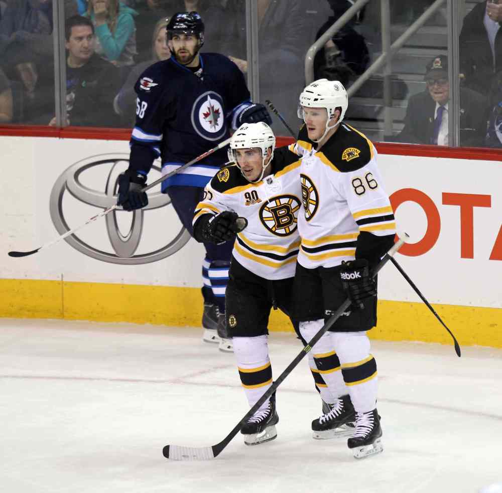 Phil Hossack / Winnipeg Free Press
The Boston Bruins' Kevan Miller (#86) pats Brad Marchand on the back for scoring the first goal of Thursday's game at the MTS Centre.