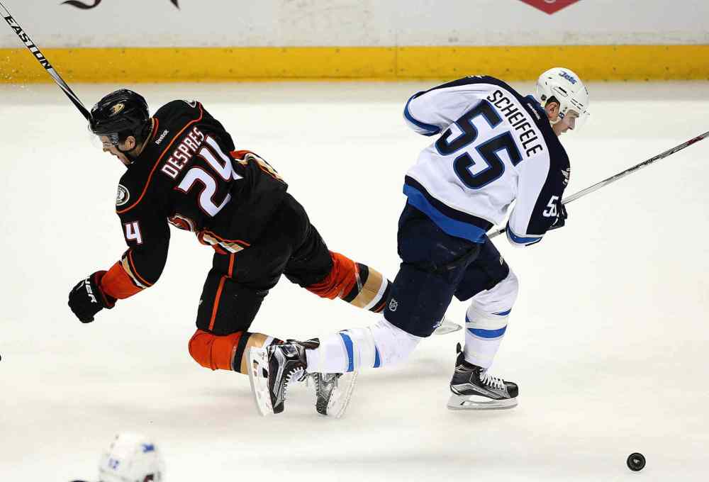 Robert Gauthier / Tribune Media TNS
The Anaheim Ducks' Simon Despres (24) whiffs on an attempted check as the Winnipeg Jets' Mark Scheifele carries the puck toward the net in the second period during Game 1 in the first round of the NHL playoffs at the Honda Center in Anaheim, Calif., on Thursday.