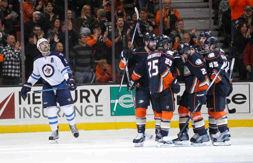 Jae C. Hong / The Associated Press
Winnipeg Jets' Mark Stuart, left, looks at the scoreboard as the Anaheim Ducks players celebrate a first-period goal by Kevin Bieksa.