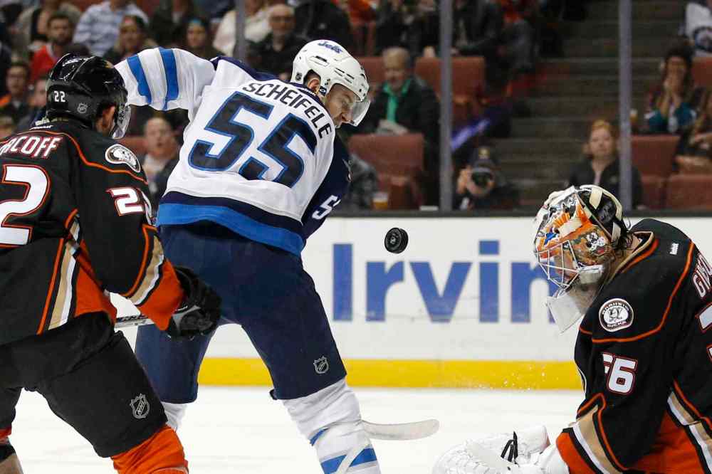 Jae C. Hong / The Associated Press
Winnipeg Jets' Mark Scheifele, second from left, looks at the puck deflected by Anaheim Ducks goalie John Gibson, right, during the first period.