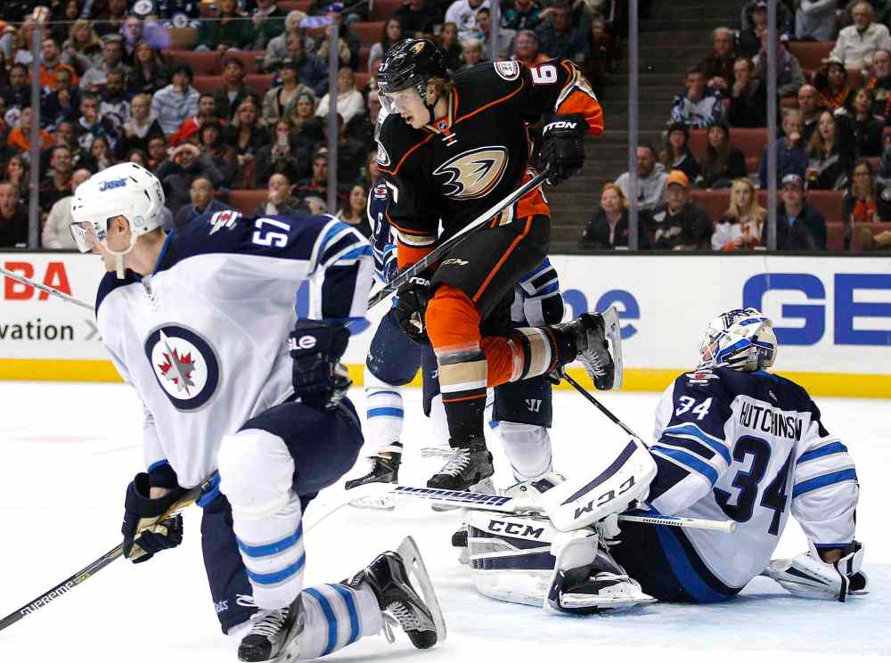 Jae C. Hong / The Associated Press
Anaheim Ducks' Rickard Rakell, centre, jumps over Winnipeg Jets goalie Michael Hutchinson, right, during second period.