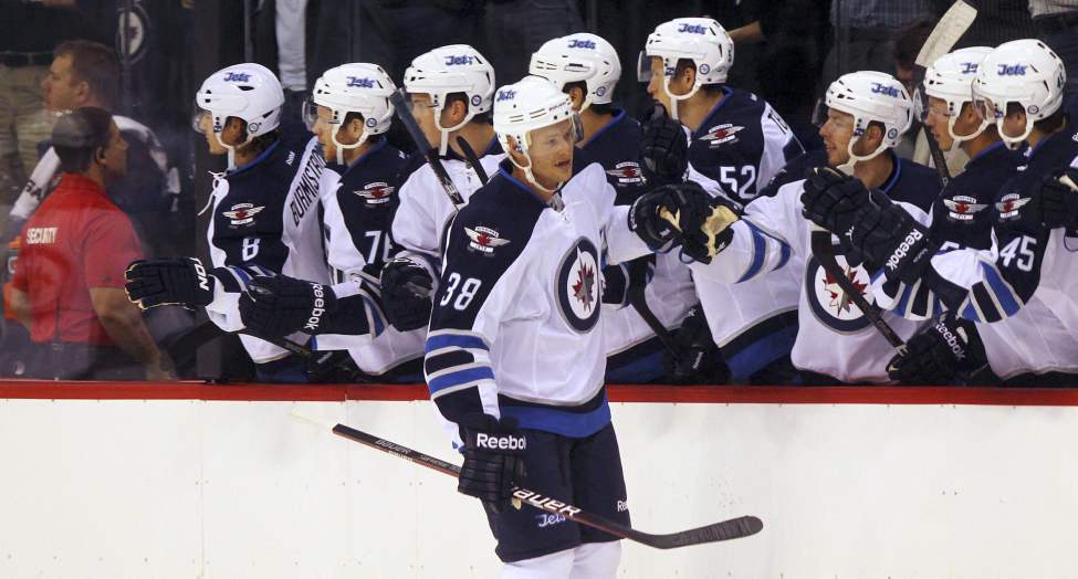 Paul Postma celebrates with teammates after scoring the first Jets Goal against Columbus in their first home game in 15 years. (Phil Hossack / Winnipeg Free Press)