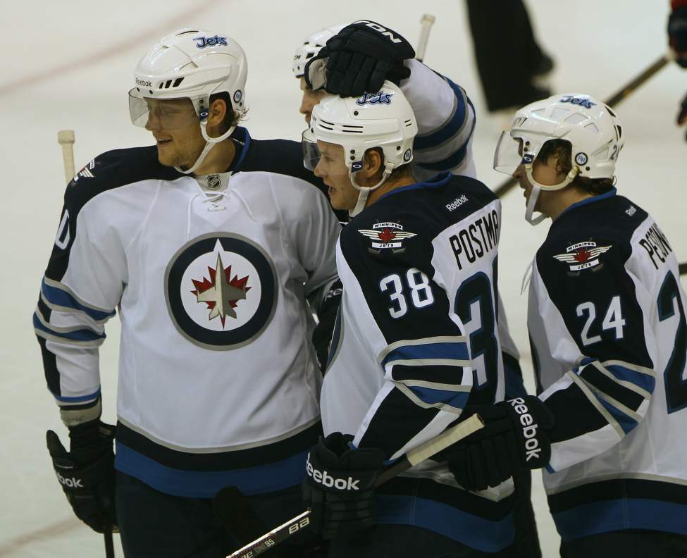 Winnipeg Jets Paul Postma, center, celebrates the first NHL goal since the Jets returned to Winnipeg with teammates Nik Antropov, left, Andrew Ladd, center-rear, and Janne Pesonen, right, against the Columbus Blue Jackets at the MTS Center in Winnipeg.
(JOE BRYKSA / WINNIPEG FREE PRESS)