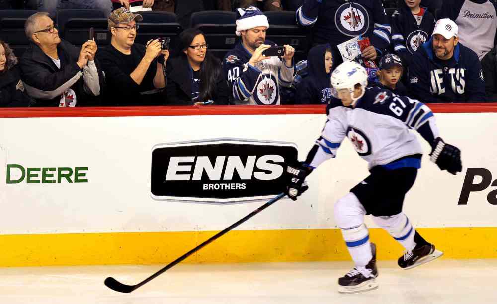 Phil Hossack / Winnipeg Free Press
Catch him if you can: Fans line up to photograph Michael Frolik during the speed skate portion of the annual Winnipeg Jets Skills Competition.