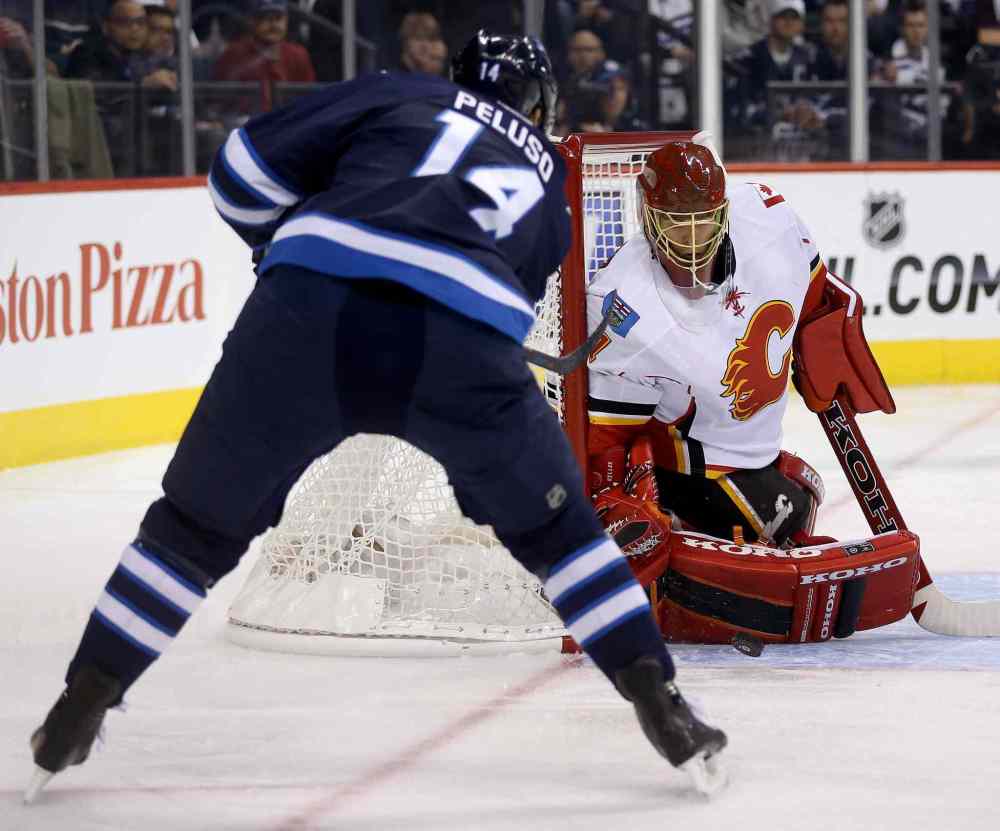 TREVOR HAGAN / THE CANADIAN PRESS
Winnipeg forward Anthony Peluso's scoring attempt is thwarted by Flames goaltender Jonas Hiller during the second period.