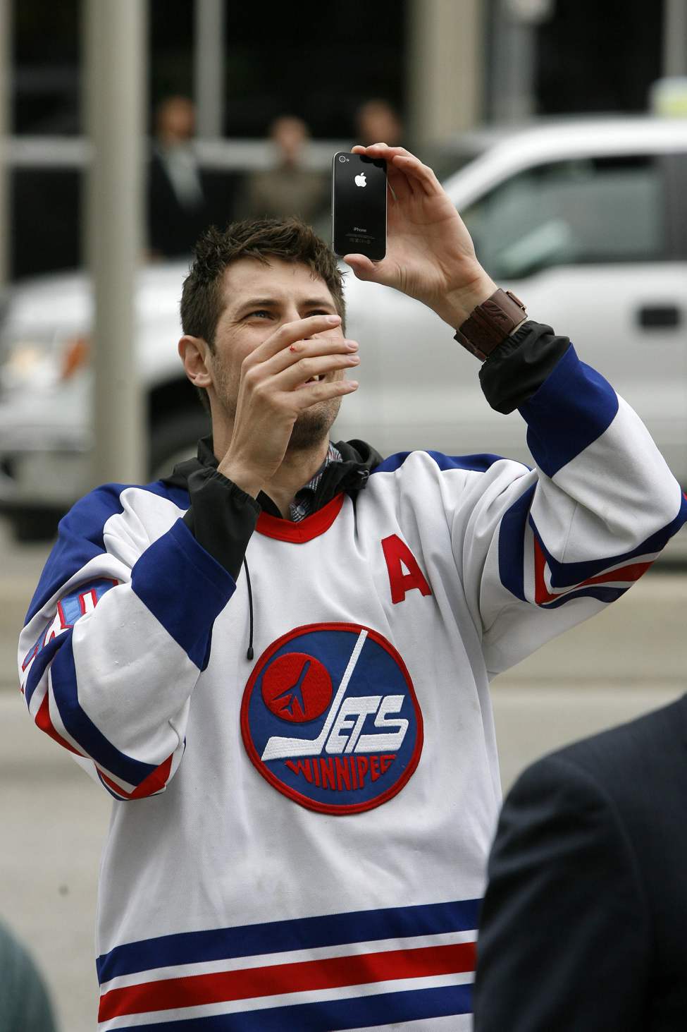 Hockey fans gathered at Portage and Main to celebrate the return of the NHL to Winnipeg, MB. Mark Zwaagstra takes photos of the crowd watching the press conference on the Global big screen. (MIKE DEAL / WINNIPEG FREE PRESS)