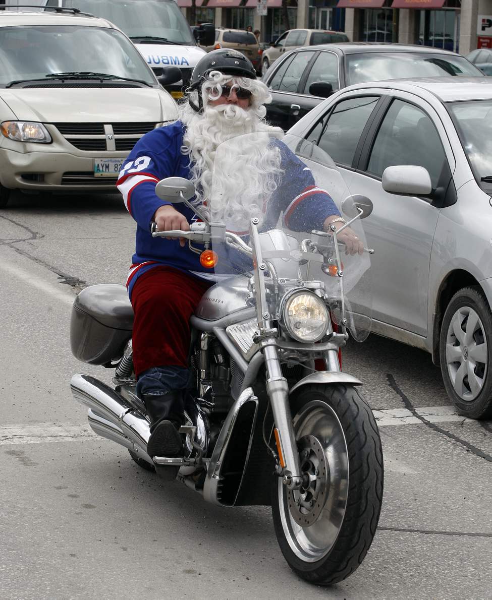 NHL comes back to Winnipeg - Yes, that's Santa riding on a Harley wearing a Selanne Jets jersey down Main Street after the rally at the Forks.
(KEN GIGLIOTTI / WINNIPEG FREE PRESS)